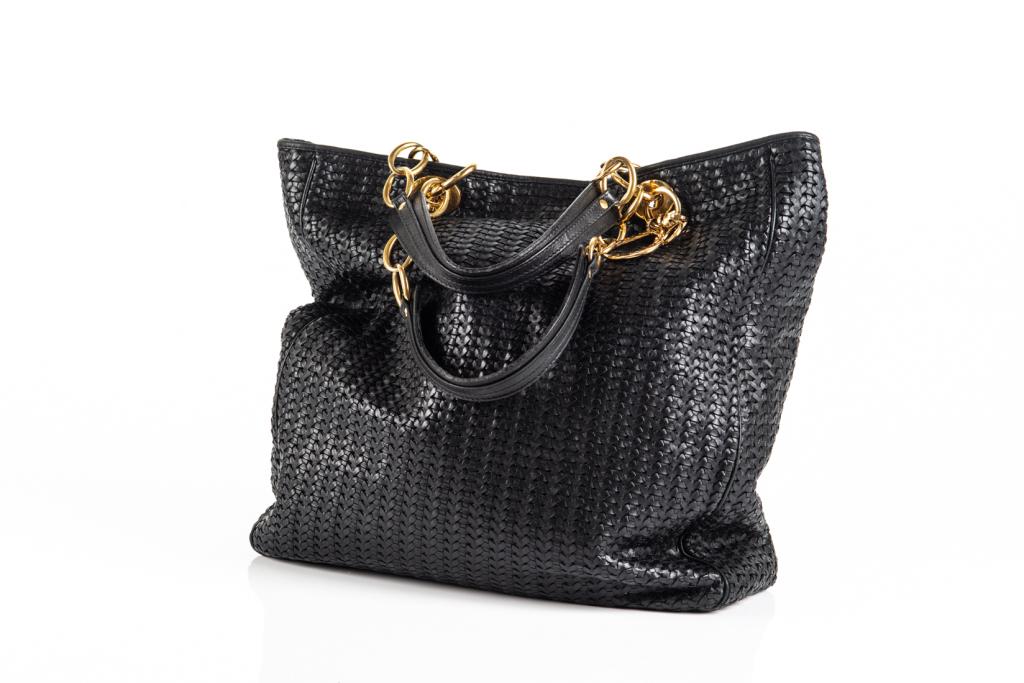 CHRISTIAN DIOR WOVEN LEATHER HANDBAG: Black Christian Dior woven soft leather shopping tote bag with gold chain strap top handles, accompanied with iconic Dior letter charms. Metal snap closure. Two side pockets and one zippered pocket on