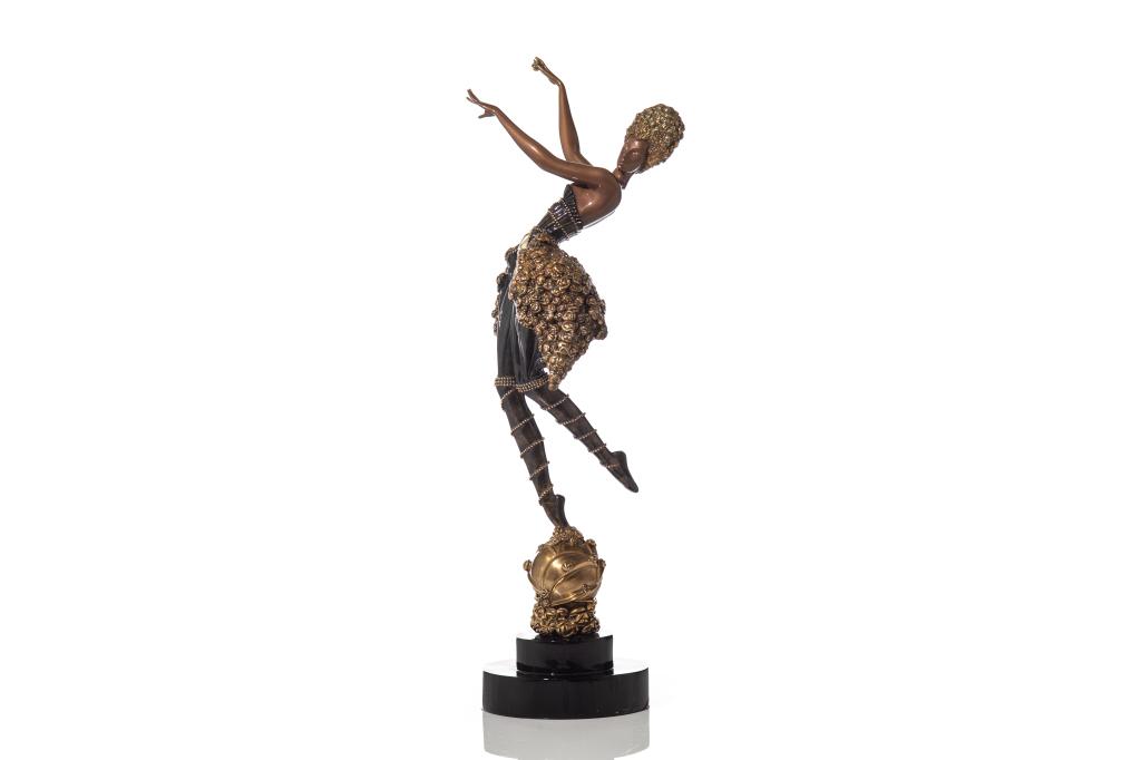PATINATED BRONZE ART DECO STYLE SCULTPURE BY ERTE: Woman dancing, arms outstretched in lavish evening wear outfit. Gilded accents on dress, figure is standing on a globe like mount and tiered circular lacquer black base. Stamped Chalk & Vermillion and