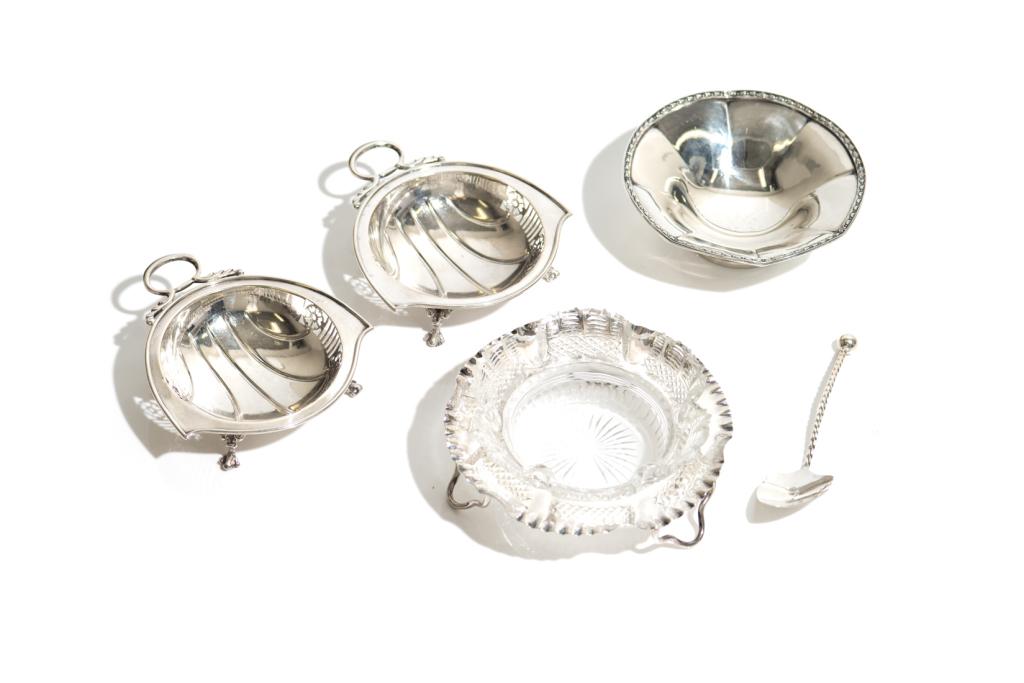 ENGLISH SILVER DISHES & GEORG JENSEN SPOONS: Including a pair of Art Deco candy dishes of a stylized shell with handle on three ball and claw feet (Birmingham, 1920), a plain lobed candy dish on foot (Birmingham, 1917), and a Victorian cutglass