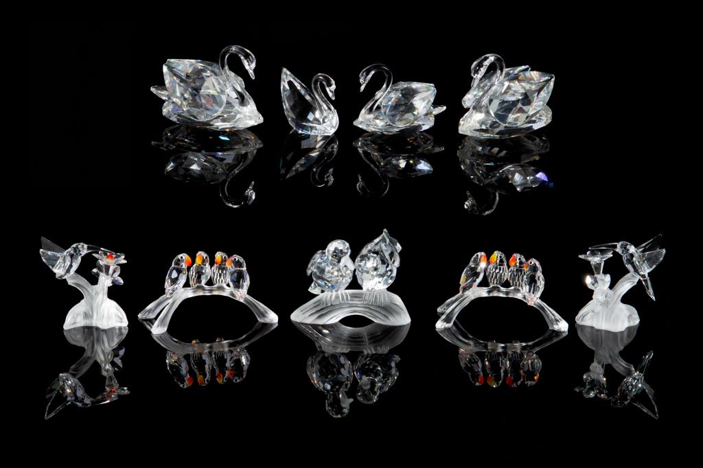 SWAROVSKI CRYSTAL COLLECTION OF BIRD FIGURES: Group of nine figurines, including: 3 figural scenes of multiple birds standing on branches, two variously designed hummingbirds and four swans.H. of largest 6.5 cm (2 1/2 in) Including two original b