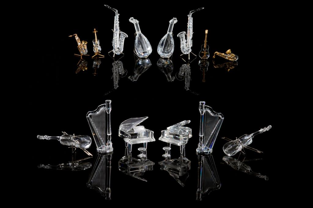 SWAROVSKI CRYSTAL COLLECTION MUSICAL INSTRUMENTS: Group of fourteen figures with various stands, including: two harps, two pianos with stools, two saxophones, two mandolins, two violins and four miniature pieces with gilded accents (twosaxophones, on