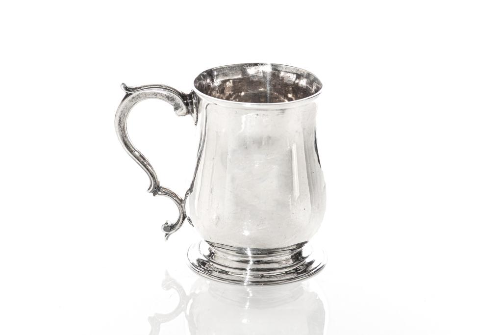 GEORGE III SILVER CHILD: Sterling silver tapered children's mug with scroll handle. Base slightly tucked above circular spreading foot. Hallmark on underside. London, c. 1770. H. 9 cm (3 1/2 in) Weight: 148 g