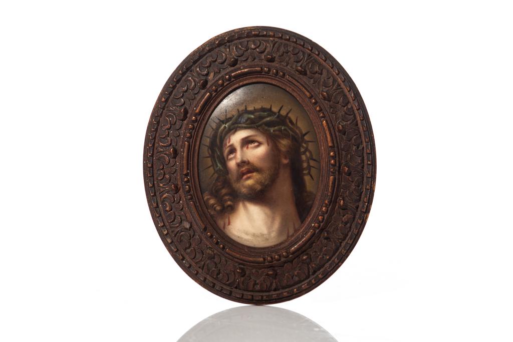 PORCELAIN HAND PAINTED PLAQUE OF CHRIST: Italian 19th century, after Guido Reni. In ornately carved oval wood frame. H. of plaque without frame: 8.5 cm (3 3/8 in) H. including frame: 13.5 cm (5 3/8 in)