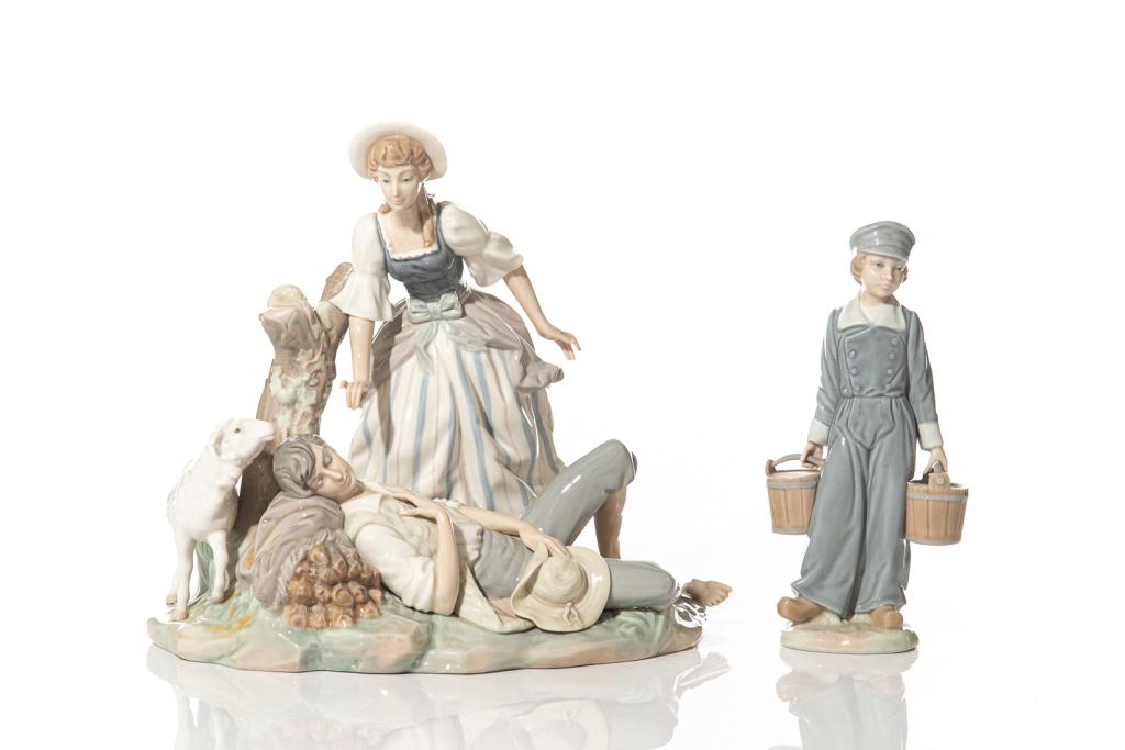 TWO LLADRO PORCELAIN FIGURAL GROUPS: Spanish porcelain, second half of 20th century. Including a large figure depicting a scene with a young woman waking a sleeping shepherd, together with a figure of a young boy carrying wood buckets of