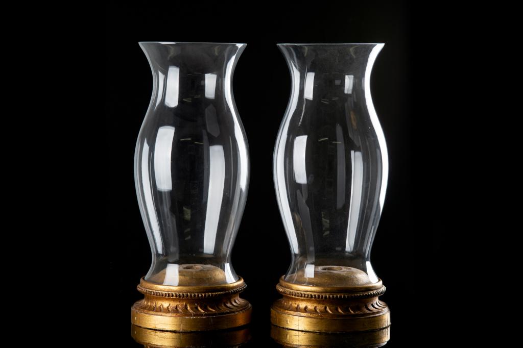 PAIR OF HURRICANE GLASS CANDLE HOLDERS WITH BASE: Each with a large antique gilded base, Italianate architectural design. Converted to hurricane lamps with tall fluted glass shades. Felted base. H. (with shade): 67cm (26 1/2 in) Dia. 27 cm (10 1/2 in