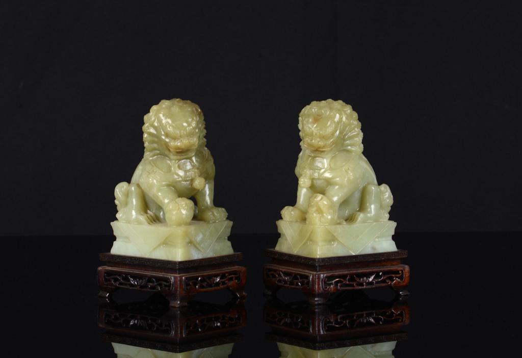 PAIR OF CHINESE NEPHRITE JADE CARVED FU LIONS: Carved as a mirroring pair of guardian lions on base. Height of carving: 13cm (5 in.) Condition report available upon request.