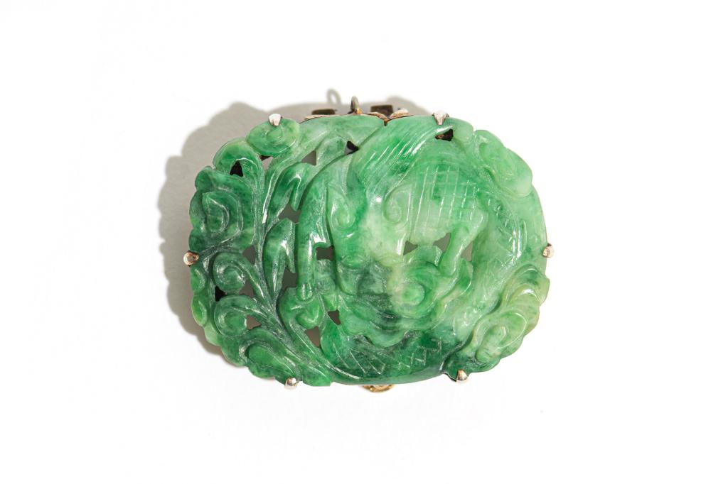 CHINESE JADEITE CARVED DRAGON BROOCH: Overall with apple green and spinach tones. Carved with dragon and clouds set on a Chinese silver backing marked China Silver Bee, and Cheng character in Chinese. W. 3.8cm (1 1/2 in.)Condition report 