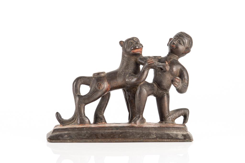 18TH C. INDIAN BRONZE BASE OF DURGA'S LION: Cast with Durga's lion attacking a titan. Remnants of painted pigments to body. H. 17.1cm (6 3/4 in.) Base size: 9 x 23cm (3 1/2 x 9 in.) Condition report available upon request.