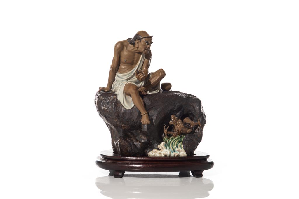 CHINESE SHIWAN POTTERY LUOHAN & DRAGON FIGURE: The luohan figure holding a pearl in hand, accompanied by a flying dragon emerging from waves below. Impressed seal mark Liu Zemian to back and cyclically dated 1982. With fitted wood stand.Height on 