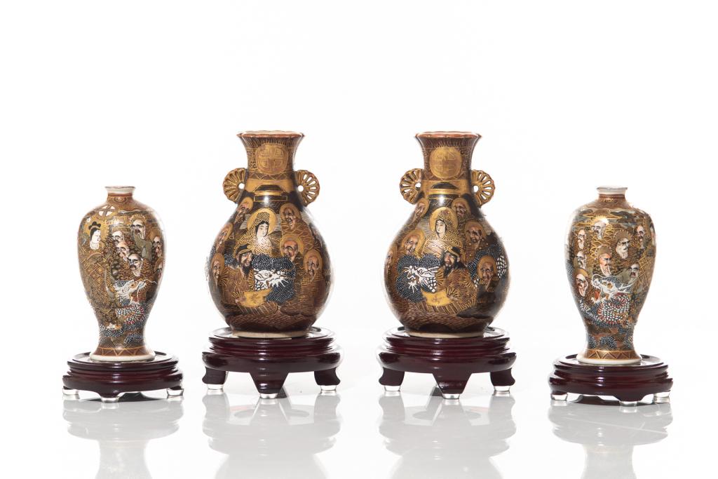 FOUR PIECES OF JAPANESE SATSUMA POTTERY VASES: Meiji era (1868-1912). Two pairs of vases, painted with faces of men and blue dragon detail. Fixed to wood stand. H. larger vases: 15.25 cm (6 inch.) H. of smaller vases: 12.7 cm (5 inch.) Conditionre