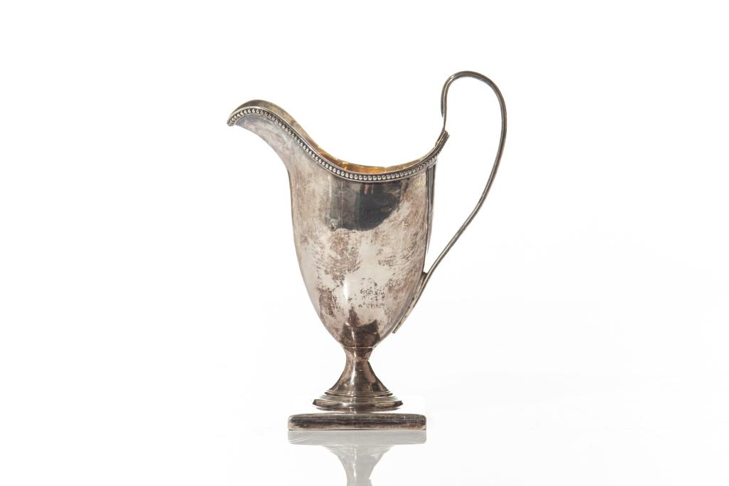 GEORGE III SILVER HELMET CREAM JUG, 95g: With a gilded interior and beaded border upon a square base. London, 1793. GC struck over original maker's mark (Peter & Ann Bateman).H. 13.4 cm (5 1/4 in.)