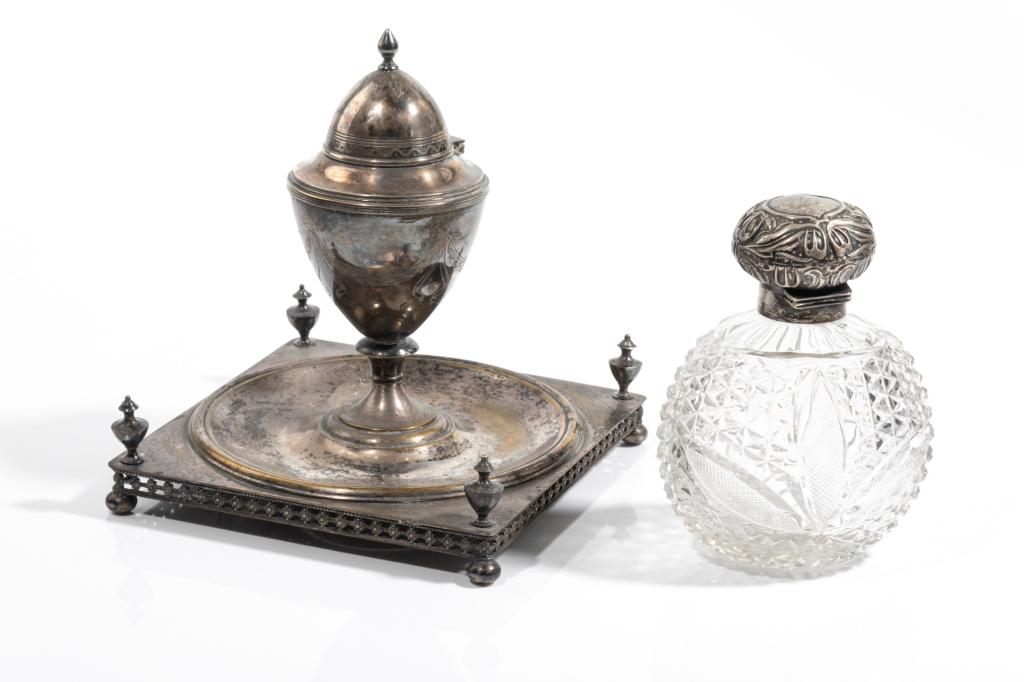 TWO PIECES OF SILVER: An English cut glass perfume bottle with silver cap (missing stopper) and a silverplated Adam's form inkwell with silver urn form well (unmarked).H of bottle 13.5cm (5 1/4in)
