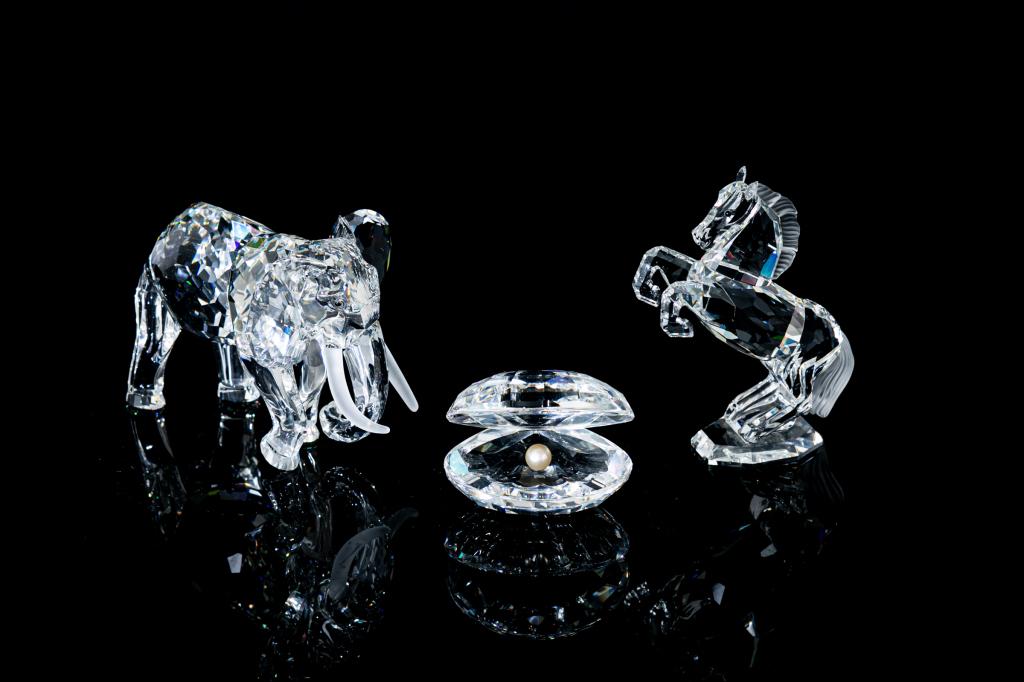 GROUP OF THREE SWAROVSKI CRYSTAL ANIMAL FIGURES: Comprising: One elephant, with frosted tusks One oyster with pearl detail One horse, rearing on back legsStamp mark on the bottom of each figure. H. of largest 11 cm (4 1/4 in) Original boxes for the