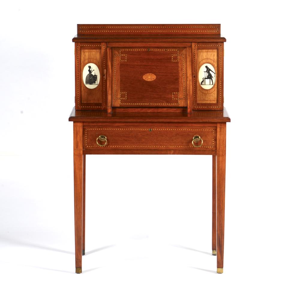EDWARDIAN MAHOGANY LADY'S WRITING DESK: Mahogany with checkered banding, brass pulls to the fitted drawer. Two cupboard drawers fitted with cut out silhouette details.H. 46 W. 29 1/4 D. 18 in. Loss to left cupboard drawer.