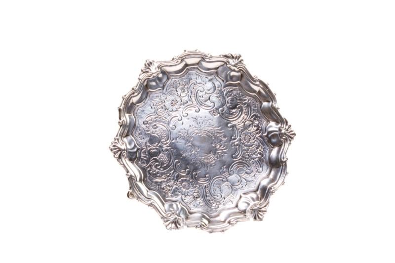 GEORGE II SILVER SMALL CARD SALVER, 285g: A footed sterling silver salver with chased decoration and an engraved central cartouche. Raised on three hoof feet. Initials partially obscured, probably James Morrison, London, 1752.Dia. 18.8 cm (7