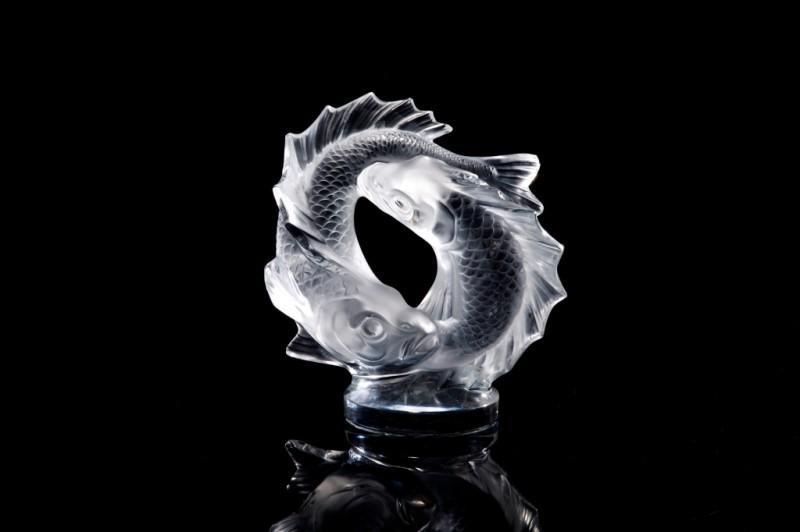 LALIQUE FRANCE GLASS DOUBLE FISH SCULPTURE: Of two intertwined fish on a circular base, designed by Marc Lalique in 1953, engraved makers mark Lalique France. H 11 in.