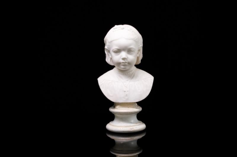 ALABASTER BUST OF A YOUNG GIRL: With ribbon in her hair, wearing a crucifix necklace mounted on a round pedestal base. H. 45 cm (17 3/4 in)Condition noted.