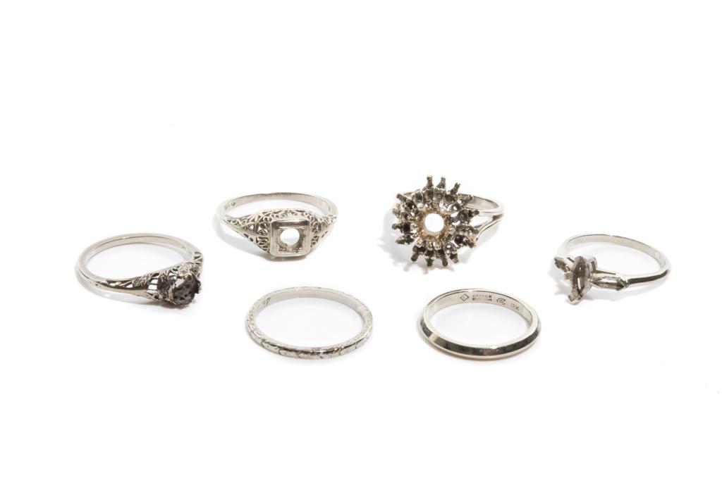 LOT OF SIX 18K WHITE GOLD RINGS, 15g: Including two wedding bands with inscriptions; and four rings with stones removed. Each stamped 18k. Sizes: ranging from 6.25-7.25. Please note: total weight.