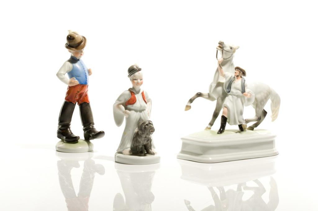 GROUP OF THREE HEREND PORCELAIN FIGURES: Hungary, includes a figure of a man walking with a white horse, a young boy with a dog and a boy wearing large boots. Blue stamp marks on the underside of each. H. of largest 21.5 cm (8 1/2 in)