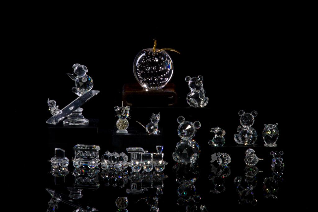 ASSORTED GROUP OF SWAROVSKI CRYSTAL FIGURES: Including a four piece train line, group of four variously sized teddy bears, two koala bears on a see-saw, a small owl, and five miniature animal figures including an owl, blow fish, bunny rabbit, bi