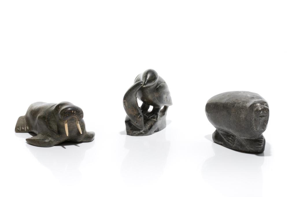 THREE INUIT SOAPSTONE CARVINGS: Isa Kasudluak Walrus with disc number E9-1701. Sarah Povungnituk Chubby Walrus with paper label. Unidentified Artist Bird Catching a Fish. L of Isa 18cm (7in)