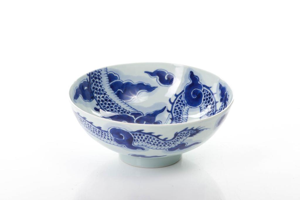 CHINESE BLUE & WHITE PORCELAIN DRAGON BOWL: 清雍正 青花過墻龍紋碗 The porcelain bowl painted with a dragon amongst clouds connected on both sides. Six character Yongzheng mark to base,