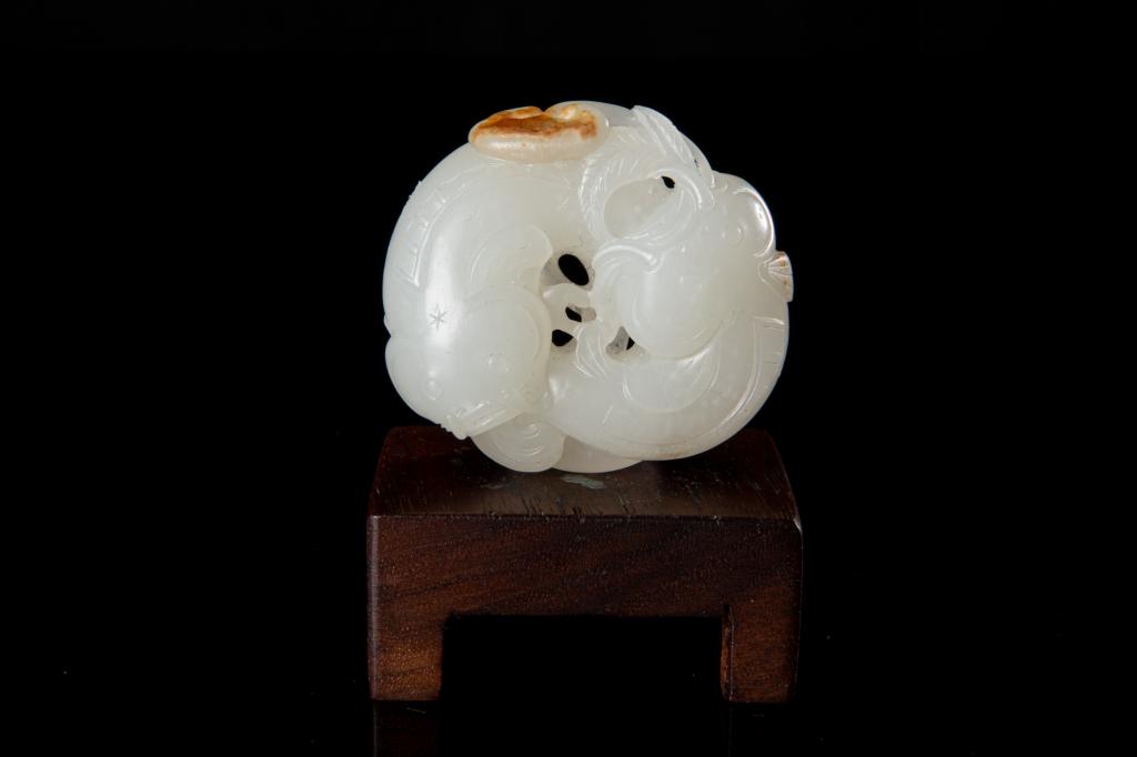 CHINESE WHITE JADE TWIN FISH AND RUYI GROUP: 清 白玉雕年年如意 The jade in overall mutton fat white tone with russet skin inclusions to one end. Carved as two fish encircling one another among ruyi