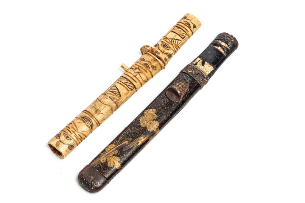 TWO JAPANESE DAGGERS: One with a carved bone hilt and scabbard, the other with an elaborate lacquer scabbard with gold embellished metal mounts. The hilt in shagreen with a devil mask pommell.