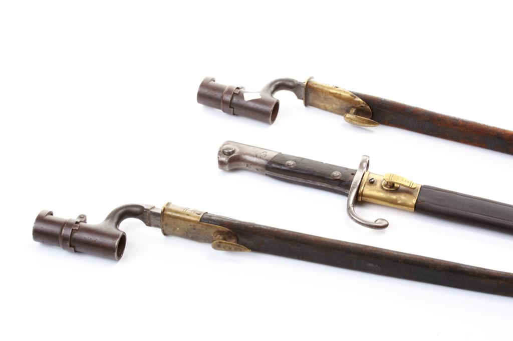 TWO ENFIELD RIFLE BAYONETS AND ANOTHER: Two triangular socket bayonets in leather scabbards for the Enfield rifle together with a 1908 pattern bayonet for the Brazilian Mauser Total length of Enfield bayonet 52 cm (20.5 inches)