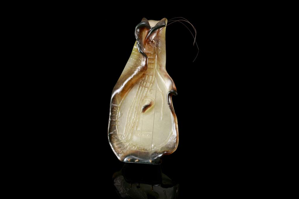 DAUM PATE-DE-VERRE SCULPTURE OF A GUITAR: In a semi-translucent yellow-green and brown glass, with strings and gilt metal tuning keys. After a design by Salvador Dali (1904-1989), signed to lower right. Moulded signature for Daumand serial nu