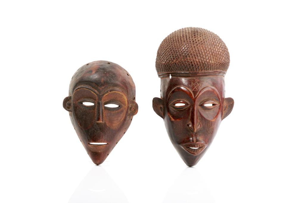 TWO CARVED CONGO AFRICAN TRIBAL MASKS: 20th century. Both masks show parted lips, slit form eyes, raised brows and long slender nose. Including a Chokwe mask, Angola / DRC with facial scarification and repeating diamond carved headpiece. T