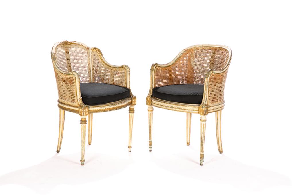 PAIR OF LOUIS XVI STYLE CHAIRS: Carved and painted with caned sides and backs. Frame embellished with green paint and gilding. Tapered reeded legs and black twill cushions. H. 34 1/2 W. 22 1/2 D. 23 in