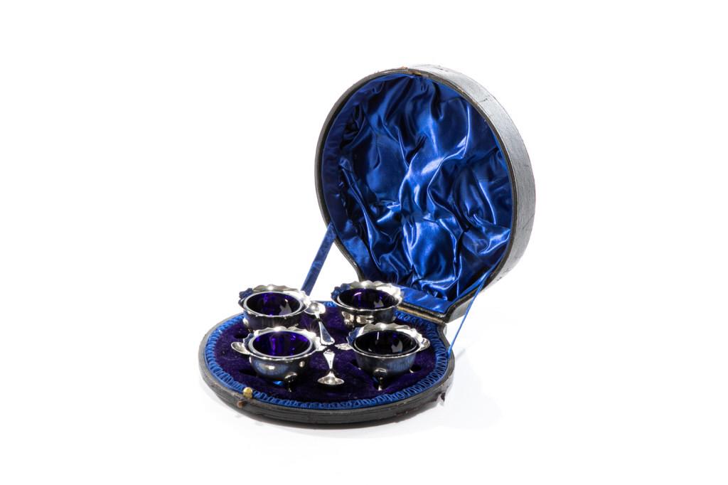 SET OF FOUR 19TH C ENGLISH SILVER SALTS, 128g: Each salt with a cobalt blue glass liner. Hallmarked to base. Wakely & Wheeler (James Wakely & Frank Clarke Wheeler), London, 1897. Together with four spoons, three hallmarked James Wakely & Frank Cla