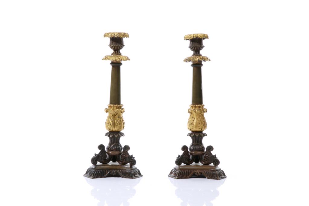 PAIR OF BRONZE PATINATED & ORMOLU CANDLESTICKS: Two-toned column form with foliate motifs throughout and acanthus detail tripod feet. French Empire, 19th C. H. 31 cm (12 1/4 in)