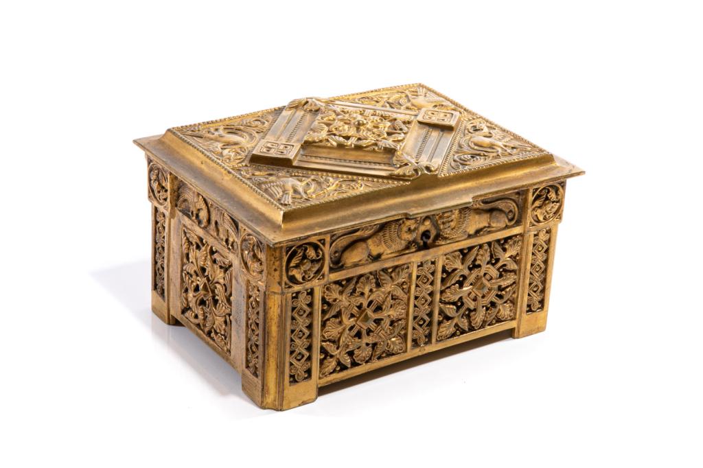 GOTHIC REVIVAL GILT BRASS JEWELLERY CASKET: The lid with a central interconnecting foliate design set within a large lozenge form and with four marginalia-style birds eating berries in the corners. The side panels of the casket are moulded with