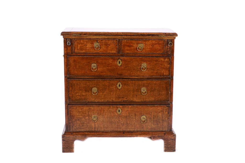 GEORGE III ENGLISH OAK BACHELOR: Provincial five drawer chest, straight sided form with simple feet and hinged butlers top, brass pulls. Late 18th/ early 19th c. H. 30 W. 28 1/4 D. 14 in Purchased from Mallett, London.