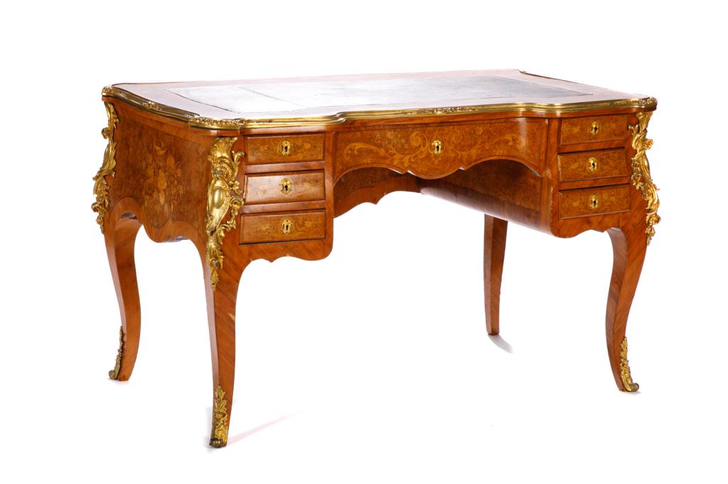 19TH C FRENCH DESK WITH ORMOLU MOUNTS: In the manner of Francois Linke with fruitwood inlay, gilt bronze banding and mounts, and leather writing surface. Central drawer flanked by six smaller side drawers. Maker's mark on back of drawer. H