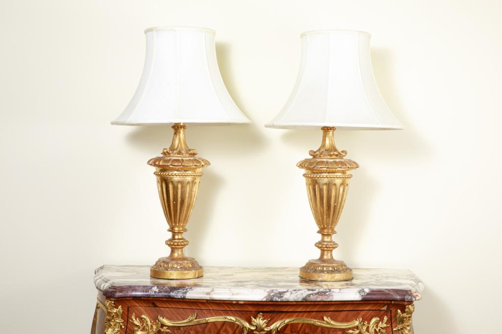 PAIR OF ANTIQUE GILTWOOD URN FORM TABLE LAMPS: Carved giltwood urns mounted as lamps, 18th C.