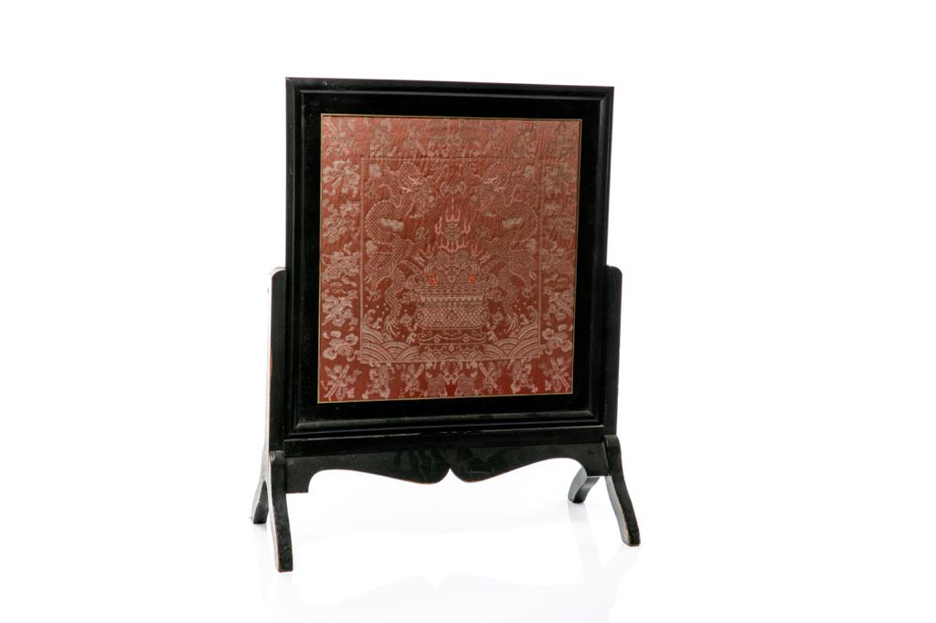 FRAMED METALLIC THREAD SILK PANEL ON STAND: Red silk ground embroidered in metallic thread with dragons and auspicious objects. 19th to early 20th C. H. on stand: 78.5cm (31 in.) Provenance: Collection of Mark and Suzanne Gayn.