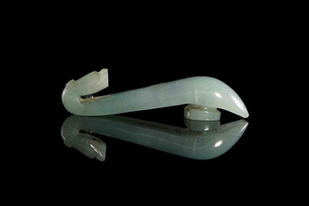 JADEITE DRAGON HEAD HOOK BELT BUCKLE: Overall in light celadon green tone, carved with a chilong dragon head form hook. 19th to early 20th C. L. 10.5cm (4 1/8 in.)
