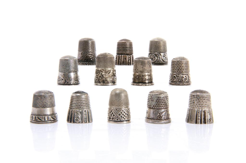 GROUP OF TWELVE SILVER THIMBLES 65g: Each marked, the majority are American and hallmarked with either Ketcham and McDougall or Simons Brothers, together with an English example and remaining variously marked sterling, indifferent design