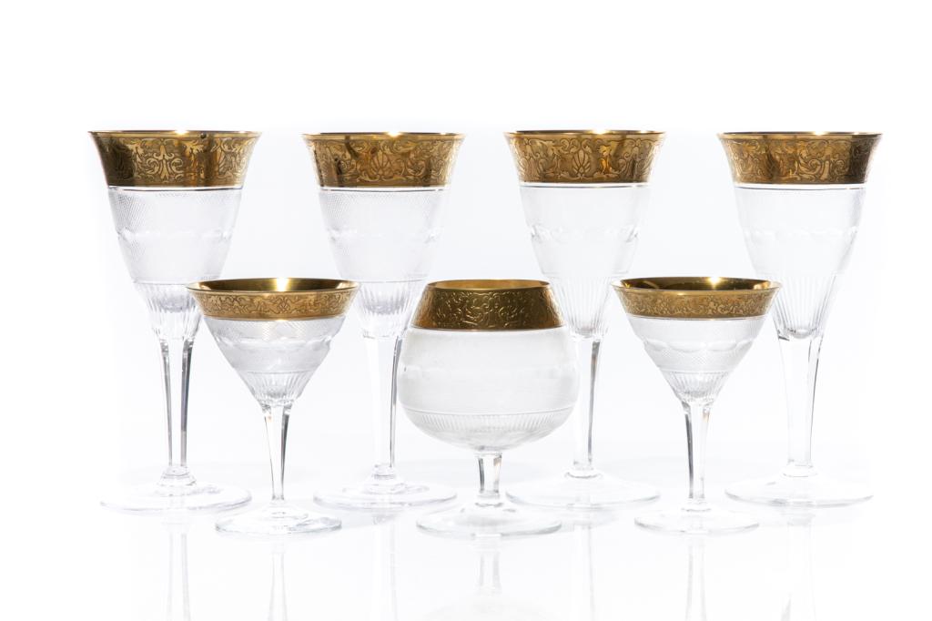 MOSER SPLENDID GOLD ENCRUSTED STEMWARE: Seven assorted stems by Moser, cut glass with thick gilded foliate embossed rims. Signed on underside. Including four water goblets, two champagne and one large brandy glass. H. of tallest glass: 23.5