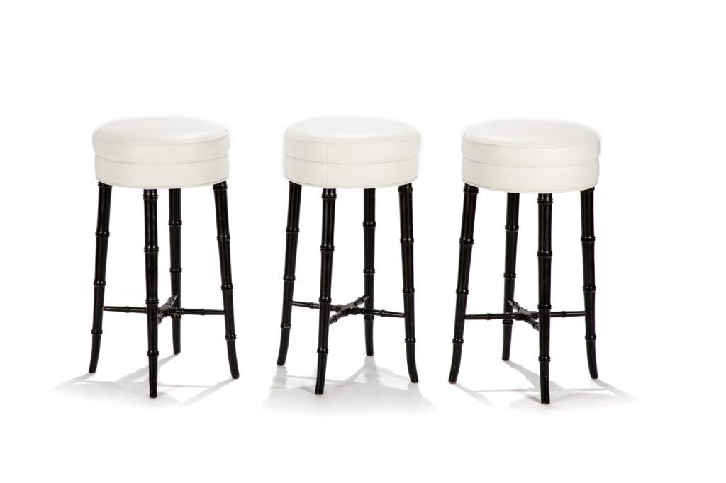 THREE LEATHER SEAT FOOTSTOOLS: Ebonized faux bamboo legs with white leather piped upholstery. H. 27 1/4 in. Dia. 15 1/2 in.