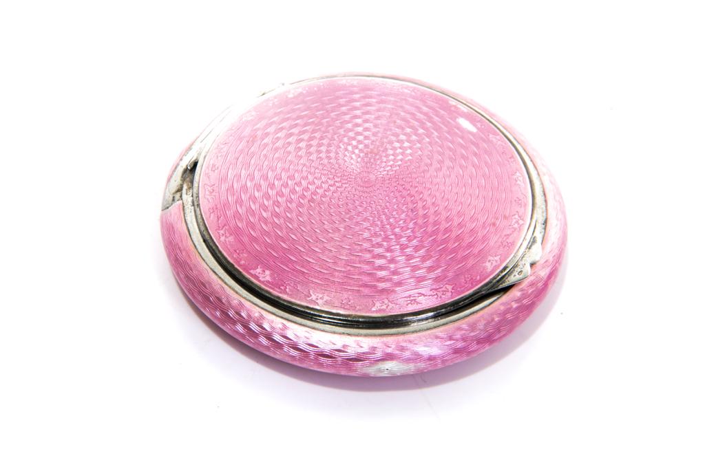 CONTINENTAL SILVER & PINK ENAMEL PATCH BOX: A circular patch box with guilloche enamelling. Opens to reveal a compact mirror and gilt interior. Hallmarked 935. Dia. 8 cm (3 1/8 in.)