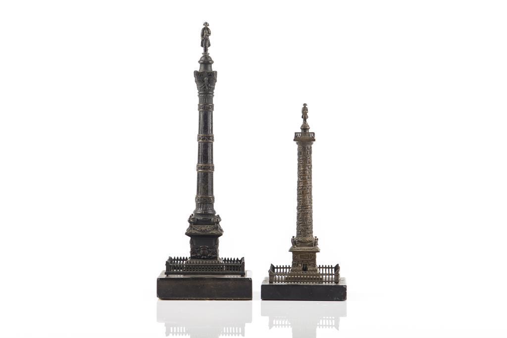 PAIR OF BRONZE ARCHITECTURAL COLUMN MODELS: Two miniature bronze statues of triumphal monuments, including the Vendôme Column from Paris. Sculptures are surmounted by statue of Napoleon wearing signature hat. Both are mounted on a square base,