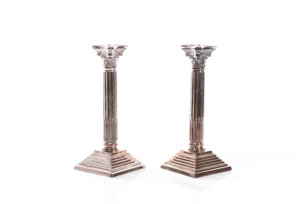 PAIR OF ENGLISH SILVERPLATED CANDLESTICKS: In the form of Corinthian columns on a stepped base. Beaded decoration throughout. Both weighted. H. 24.7 cm (9 3/4 in.)