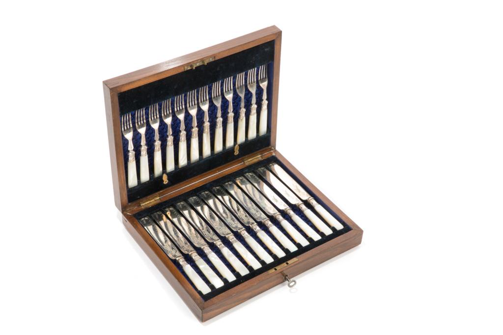 24 PIECE MOTHER OF PEARL DESSERT SET: Including twelve four-tined dessert forks and twelve dessert knives with silverplated forks and blades, and mother of pearl handles. Blades are engraved and hallmarked AF&Co. Set within a bluesilk- an