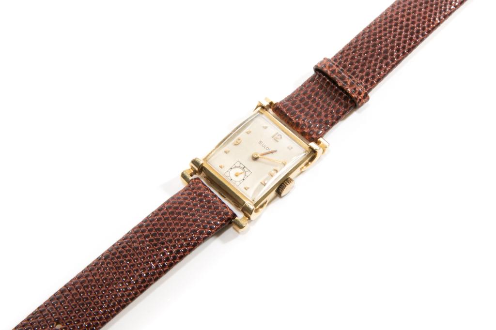 VINTAGE MAN'S GOLD BULOVA WRISTWATCH, 29g: Rectangular yellow gold casing marked gold and testing 14k. Face with mother of pearl, manual wind and marked Bulova. Reverse marked Bulova with serial number 5328310. On a brown leather strap. Strap 