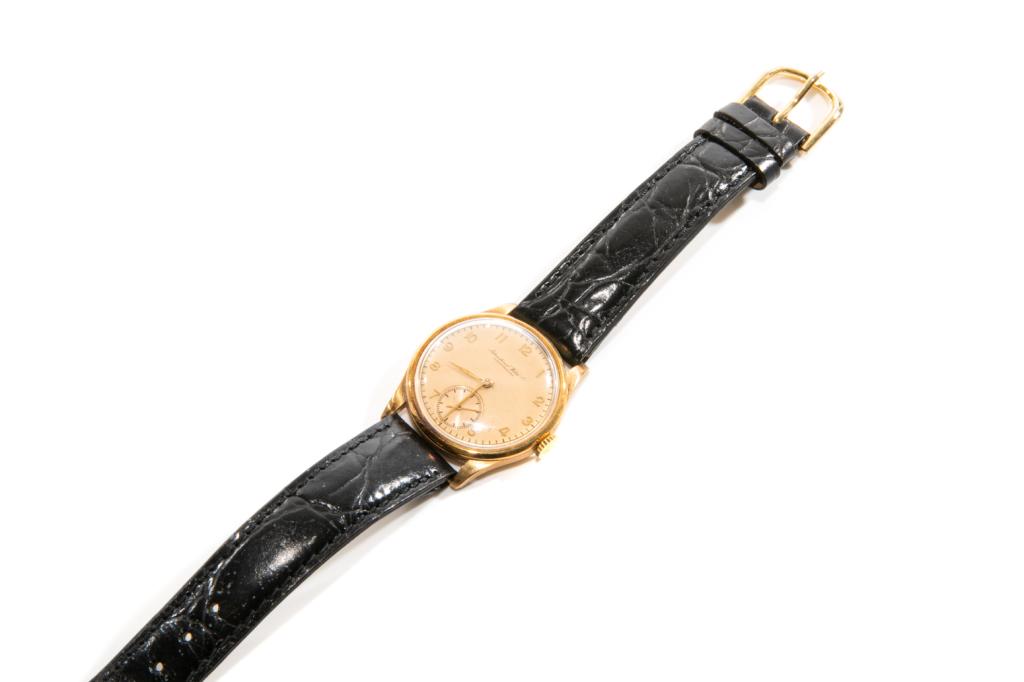 VINTAGE IWC INTERNATIONAL WATCH COMPANY WRISTWATCH: Man's gold case wristwatch on black alligator strap. Gold face with Arabic numerals. Case testing 14k. Alligator strap not original. Weight: 29g Bidders living outside of Canada are warned to proceed 