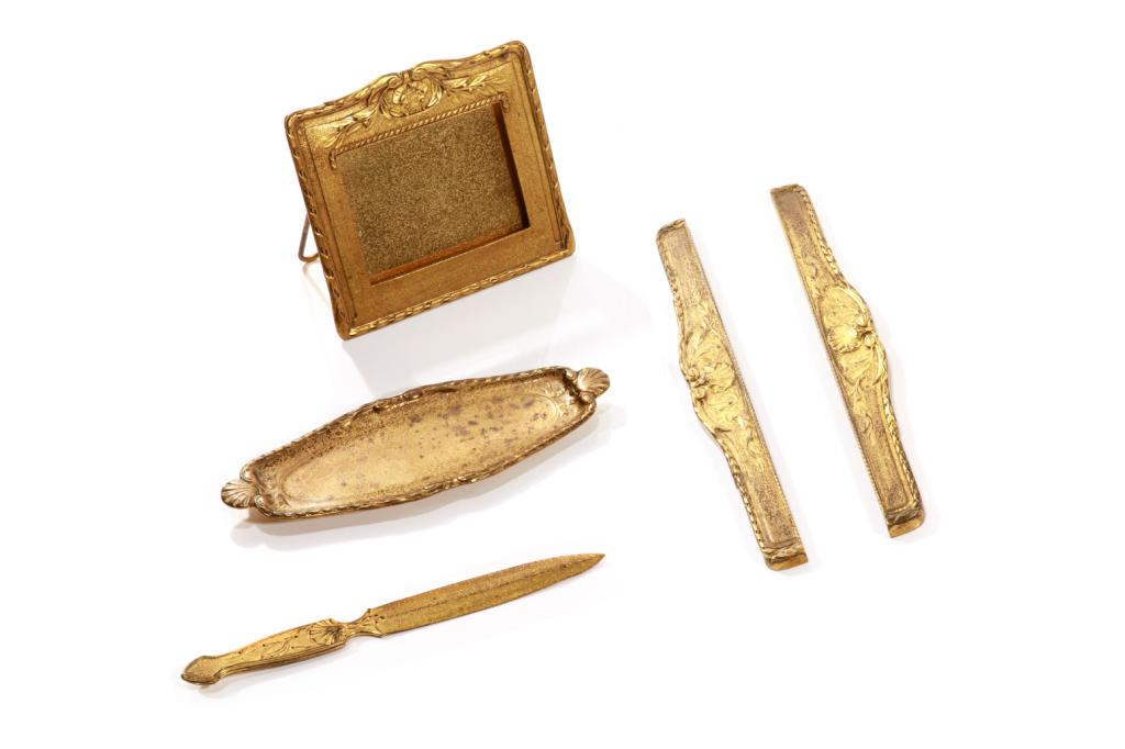 FOUR PIECE TIFFANY STUDIOS BRONZE DORE DESK SET: Acid etched gilt bronze desk accessories, each piece in the Louis XVI pattern, marked "Tiffany Studios New York," and inclusive of the pattern number. Comprising letter knife/opener (#1824), picture/p